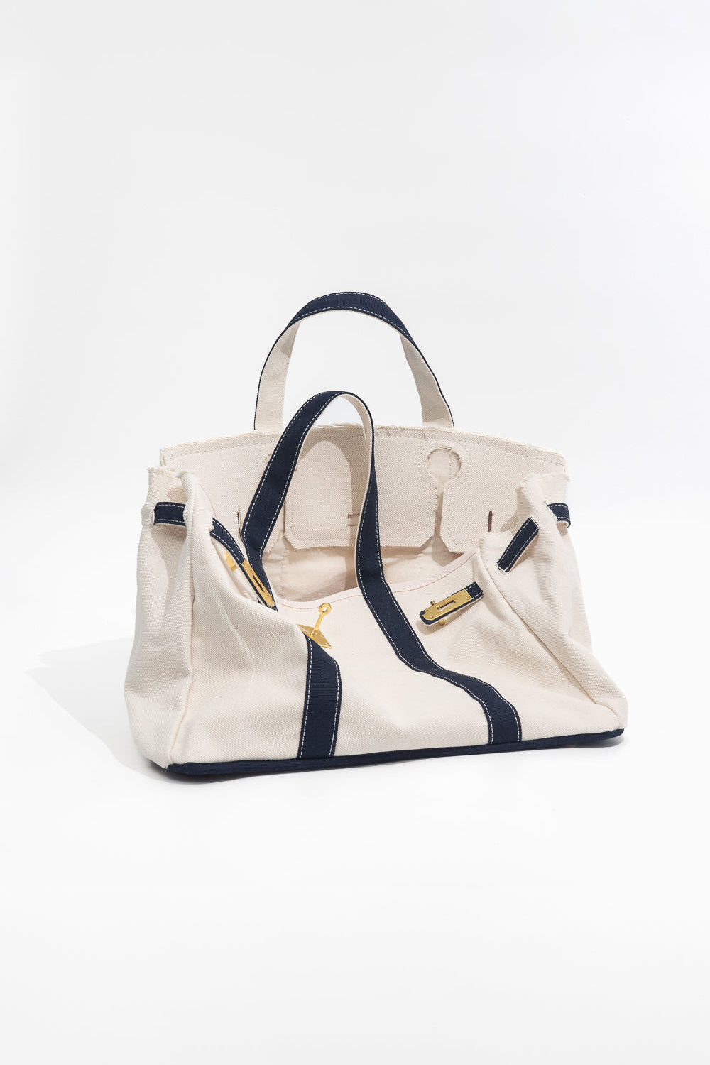 Beige handbag with navy accents on a white background