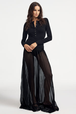 Woman wearing a black long-sleeve Henley bodysuit on a white background