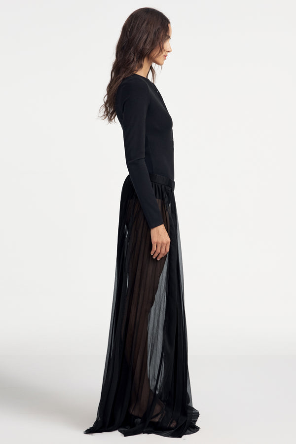 Woman wearing a black long-sleeve Henley bodysuit on a white background