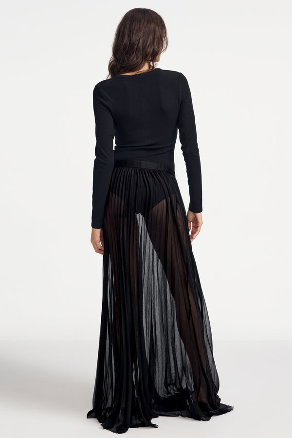 Woman wearing a black long-sleeve Henley bodysuit on a white background